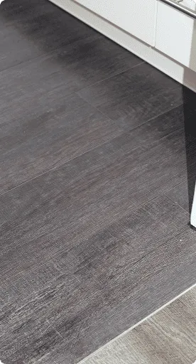 Dunkelgrauer Bodenbelag mit Holzstruktur in einer modernen Küche.